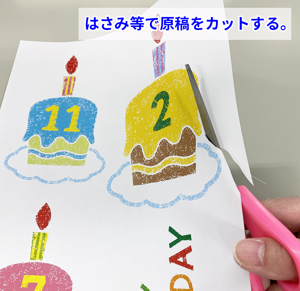誕生日パーティのフリー素材イラストをA4用紙に印刷したものをはさみでカット