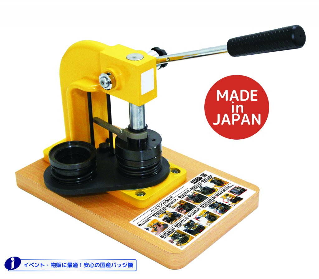 木製の台座に設置された、黄色と黒の缶バッジマシン（プレス機）のクローズアップ画像。右側には赤い円の中に「MADE in JAPAN」と書かれている。