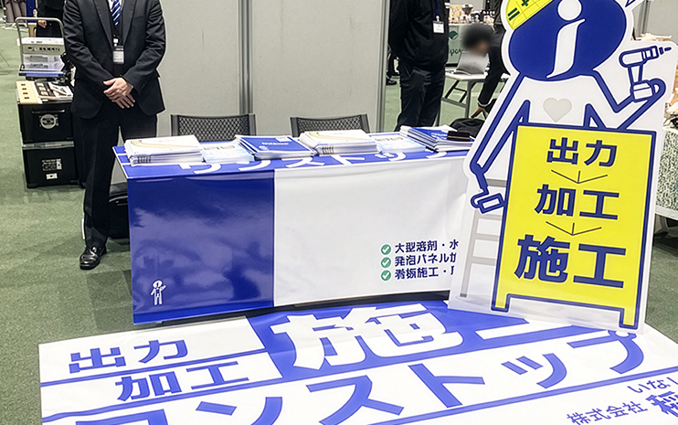 支給のテーブルに掛けたテーブル・カバーと足元のフロアシートと等身大パネル